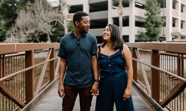 a man and a woman looking at each other and holding hands